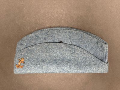 grey felt hat with a gold anchor on the front of it