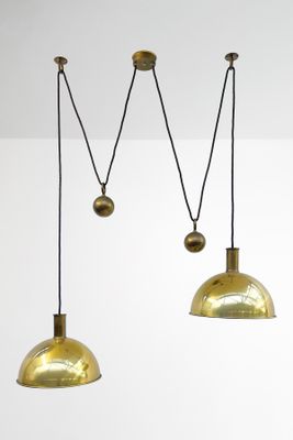 three brass colored pendant lights hanging from a ceiling