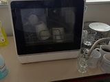 un micro-ondes posé sur une table, à côté d'une tasse de café