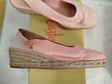 two pairs of pink shoes sitting on top of a box