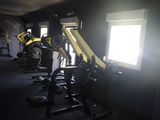 dimly lit gym room with equipment and windows in dark room