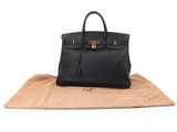 a black leather handbag with gold hardware on the handle