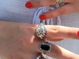 une femme aux ongles rouges et portant une bague au doigt