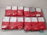 un tas de chaussettes Nike Dri-Fit rouges posées sur une table blanche