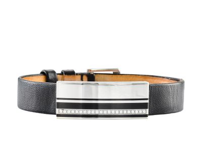 un gros plan sur un bracelet en cuir noir muni d'une boucle en argent