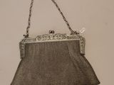 un vieux sac à main accroché au mur par une chaîne