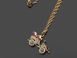 un collier en or orné d'un pendentif représentant un cheval et une calèche