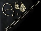 a close up of a pair of earrings and a necklace on a black background