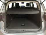 the back of a silver car with the trunk open and luggage in the trunk