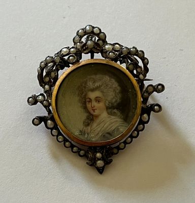 portrait d'une dame dans un cadre ouvragé, posé sur une surface blanche