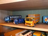 de nombreux camions miniatures posés sur une étagère dans une pièce