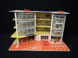 une maquette représentant un bâtiment avec un parking devant