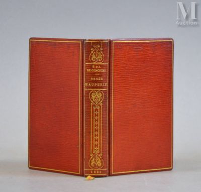 un livre rouge posé sur une table blanche