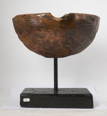 an old wooden bowl sitting on top of a black stand