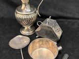 une image représentant un pichet en argent, une cuillère et d'autres objets sur fond noir