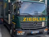 deux camions garés l'un à côté de l'autre devant un immeuble