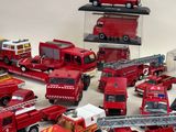 a lot of toy firetrucks and trucks on the table