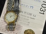 a watch on a piece of paper next to a coin