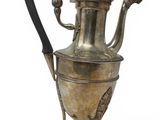 an antique silver tea pot with a handle on a stand