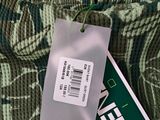 a green and white sweater with a tag on it