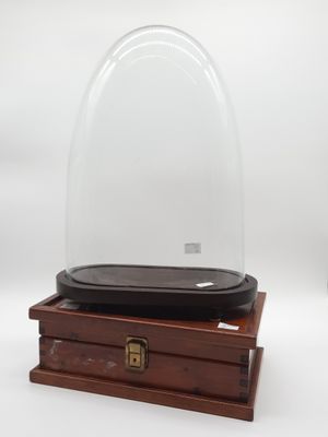 une boîte en bois vide surmontée d'un dôme en verre