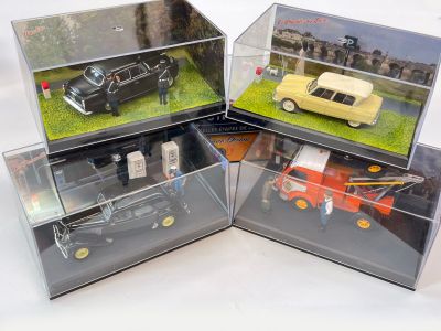 trois modèles de voitures différents exposés dans des vitrines posées sur une table