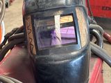 a welding helmet sitting on top of a pile of wires