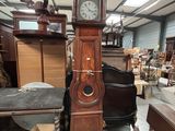 une grande horloge de parquet trônant au milieu d'une pièce