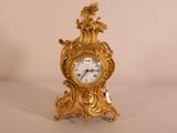 a gold clock sitting on top of a white table