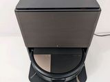 a close up of a black speaker on a stand on a white surface