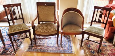 quatre chaises dans une pièce où il y a un tapis au sol