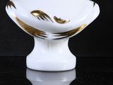 a white and gold bust of a woman sitting on a table