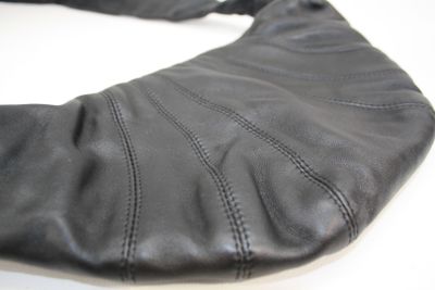 un gros plan sur un sac à main en cuir noir posé sur une table