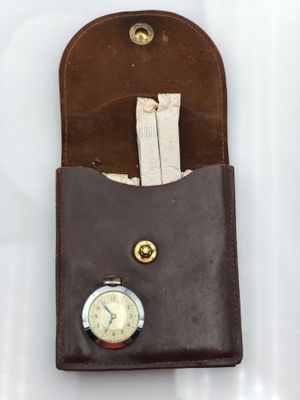 étui en cuir marron avec une poche pour une montre et une poche pour une montre de poche