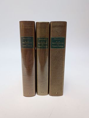 trois livres superposés sur une surface blanche