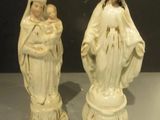 two figurines of the virgin and child are sitting on a table