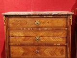 une commode en bois avec un plateau en marbre, exposée