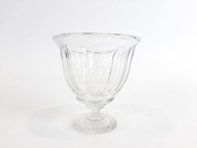 un vase en verre transparent posé sur une surface blanche