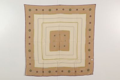 un foulard carré marron et blanc accroché à un mur