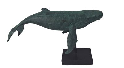 statue of a humpback whale on a black base on a white background