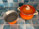 une casserole et une poêle posées sur un sol carrelé