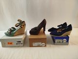 three pairs of women ' s shoes sitting on top of boxes