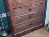 une commode en bois dans le coin d'une pièce