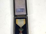 a small box with a medal and a dice in it