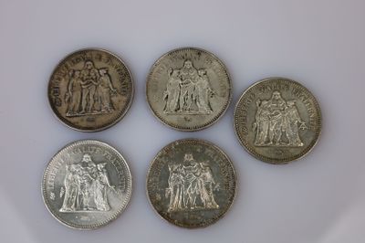 six types différents de pièces d'argent sur une surface blanche