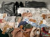a large pile of clothes and shoes on a shelf