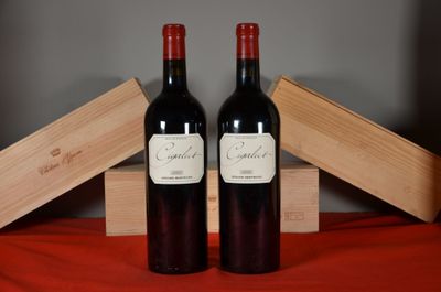 two bottles of red wine sitting next to each other on a table