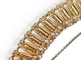 an image of a gold bracelet with a chain on a white surface