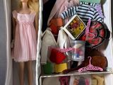 une poupée qui se trouve dans une boîte remplie d'objets divers