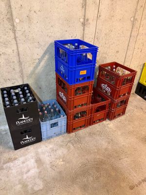 de nombreuses caisses de bière alignées les unes à côté des autres sur le sol